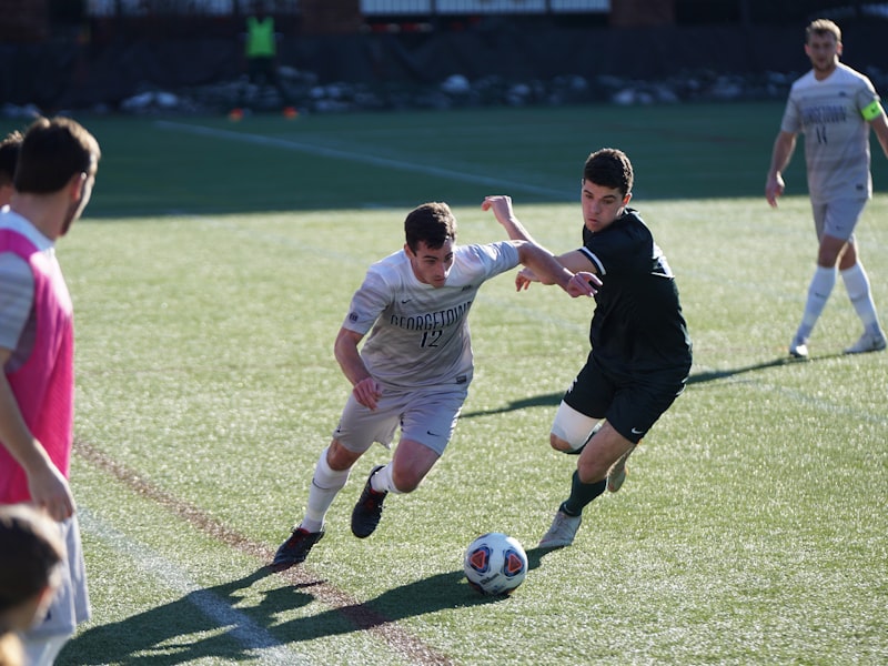 Two players competing for the ball during a Harborline FC league fixture