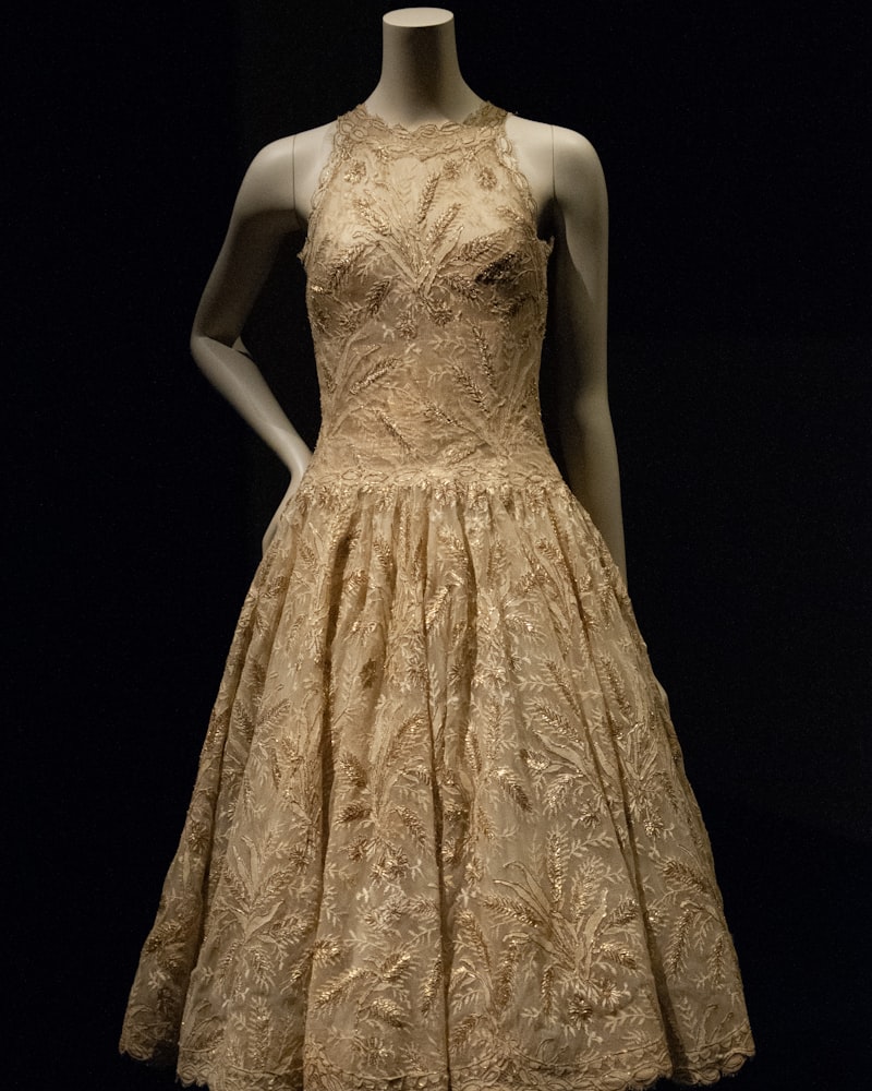 A tiered lace midi dress displayed on a tailor's form