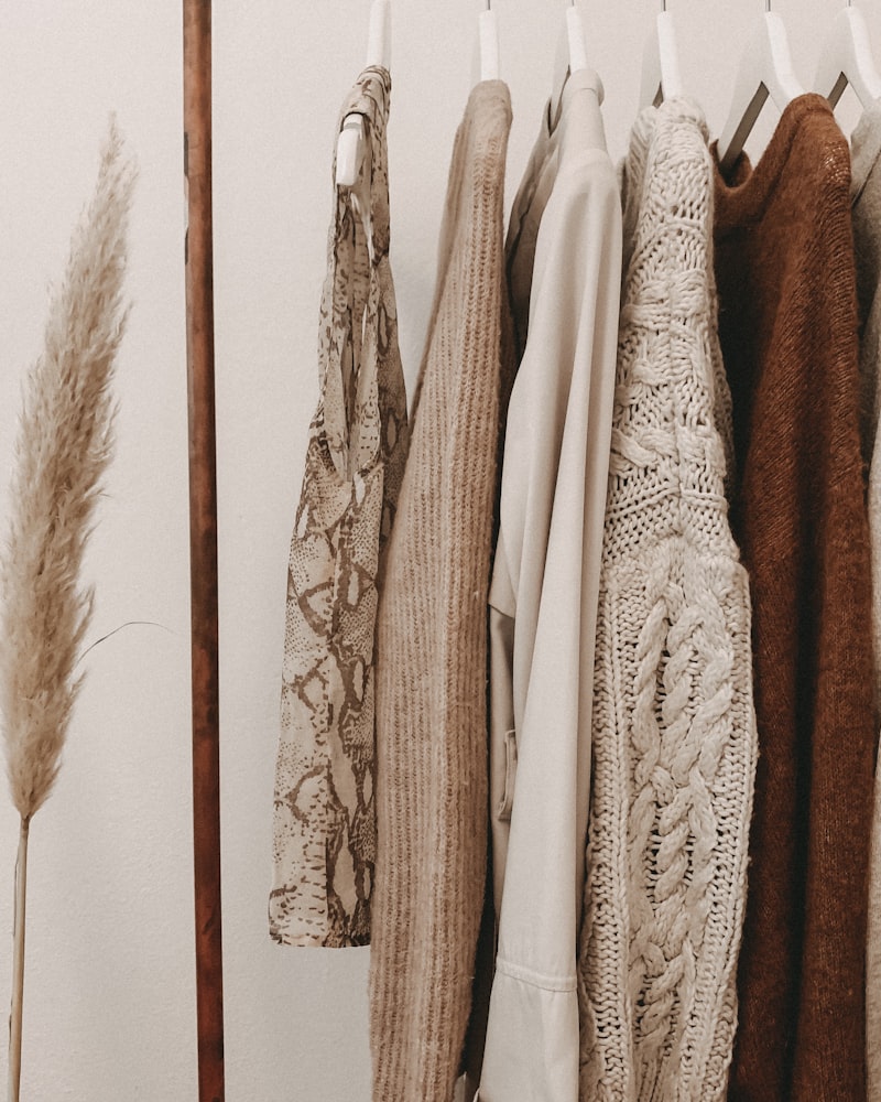 Neutral knitwear hung beside dried pampas grass