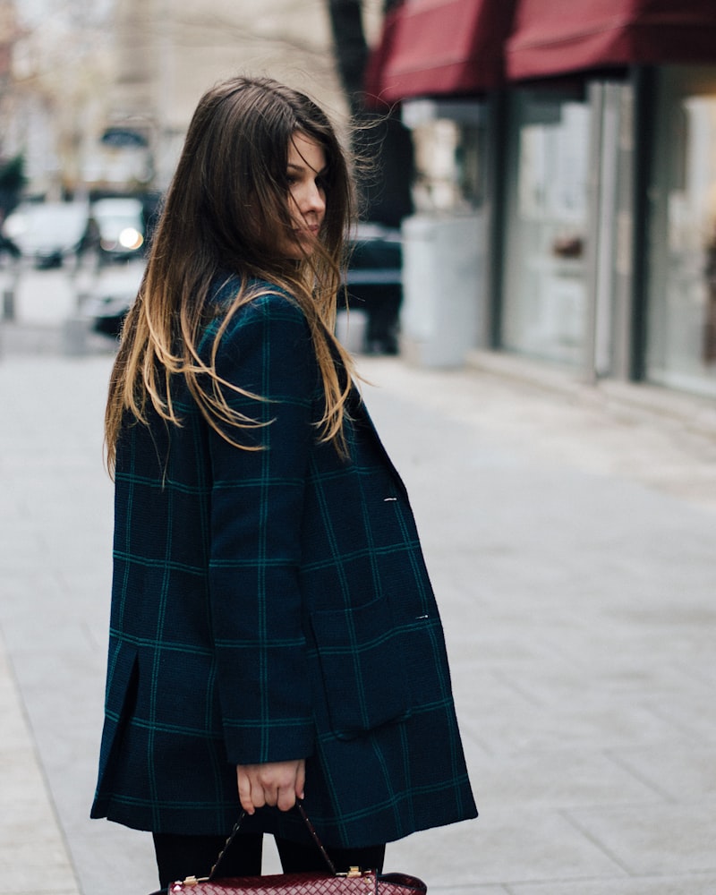 Model in a checked wool cape coat on a city street