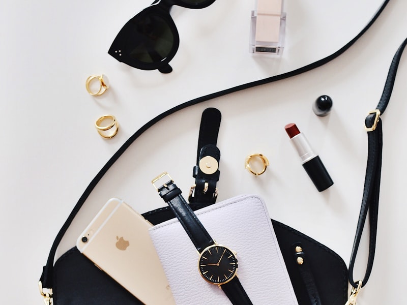 A flat-lay edit tray of sunglasses, a watch, a belt and fragrance