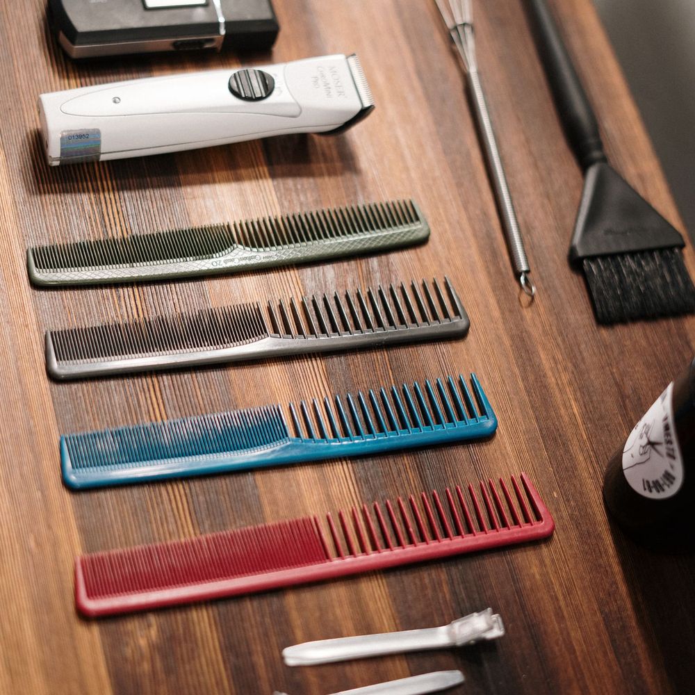 Combs, clippers and brushes arranged on a warm wooden station