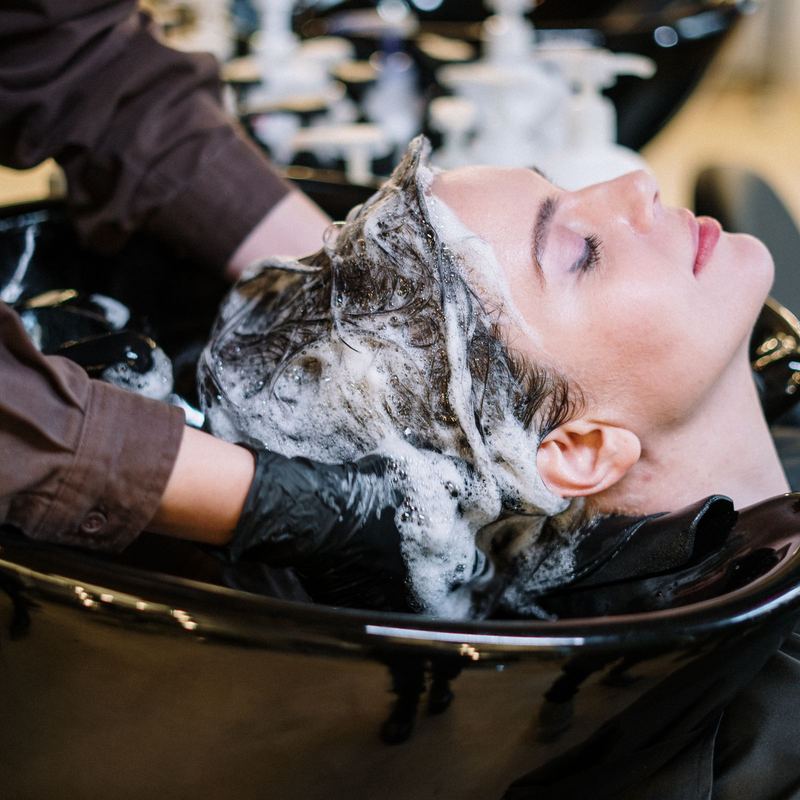 Hair being rinsed at a black backwash basin
