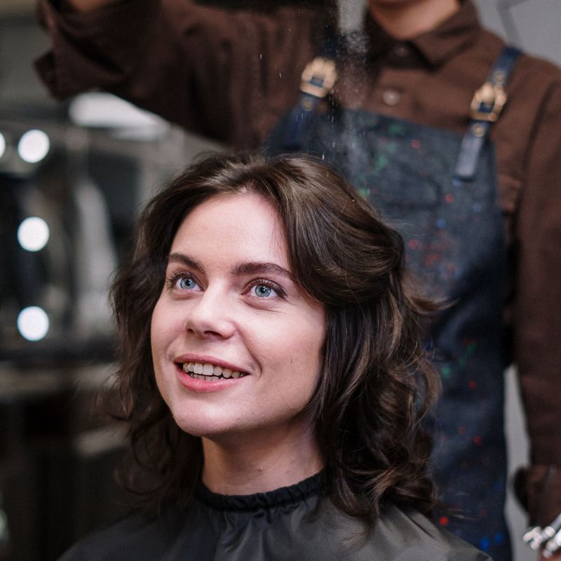 A freshly finished client smiles in the styling chair