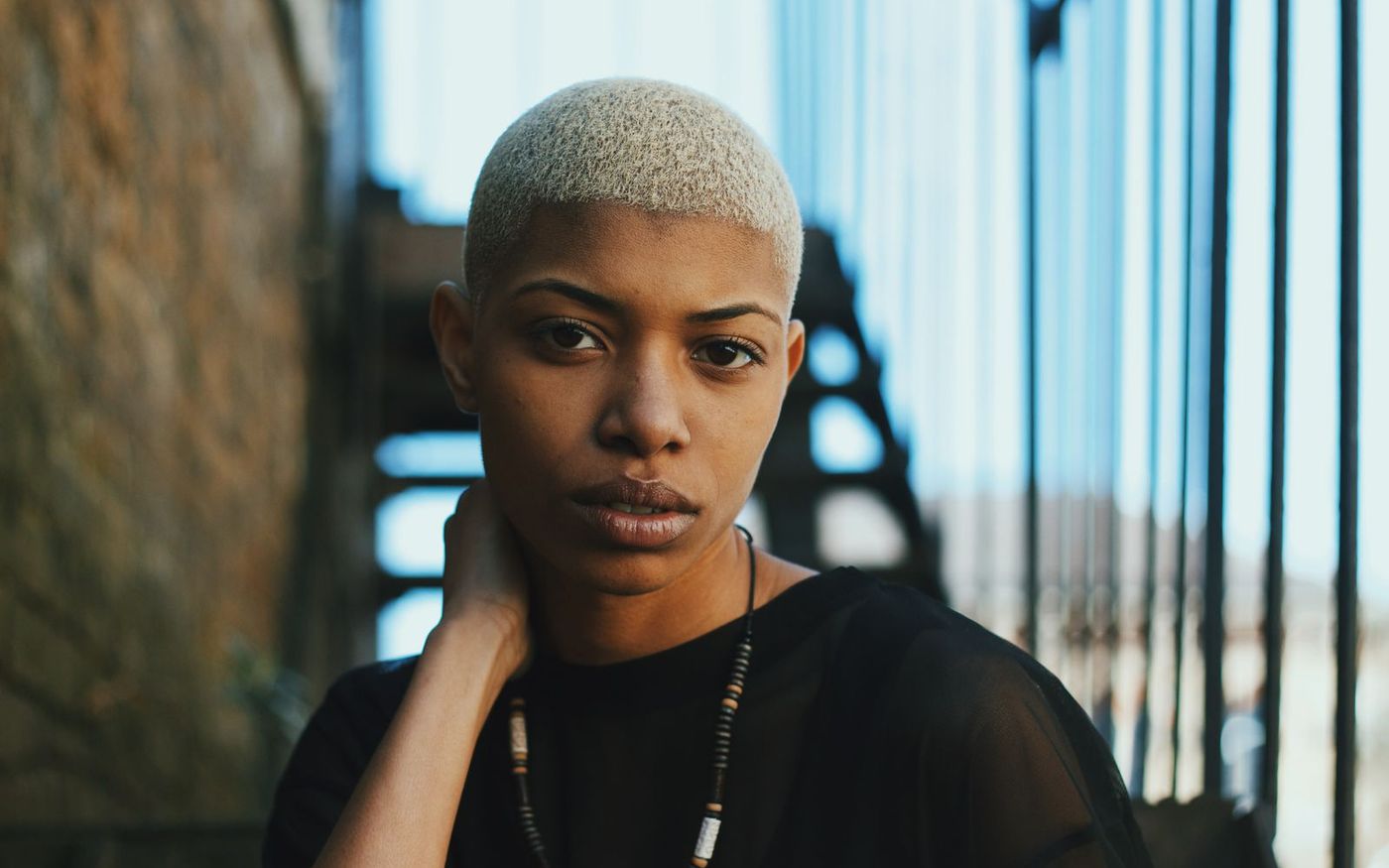 A bleached buzz cut in moody blue light