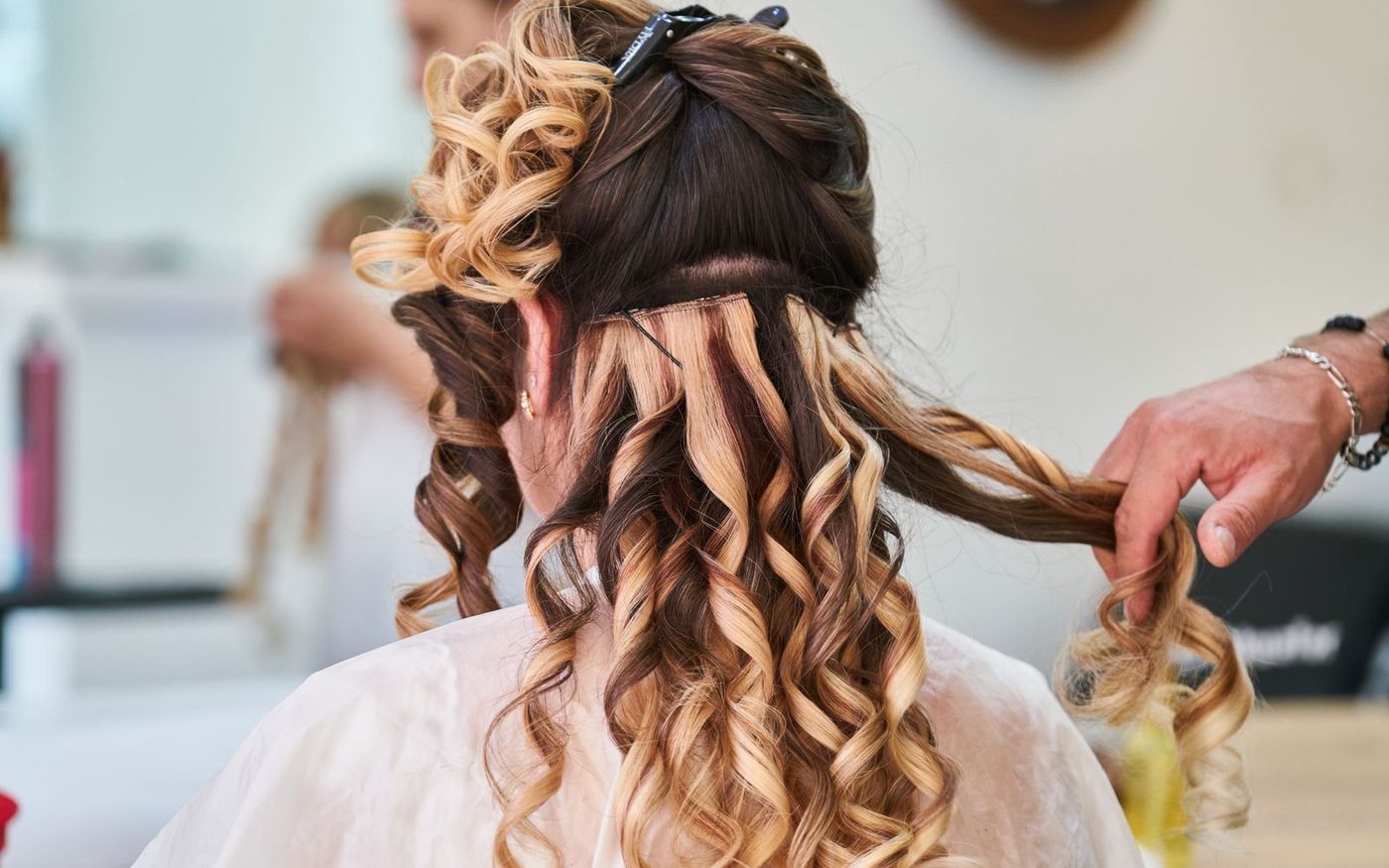 A bridal updo with soft curls being pinned into place