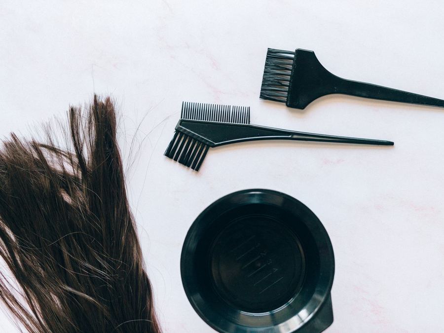 Tint brushes and a mixing bowl laid out on marble