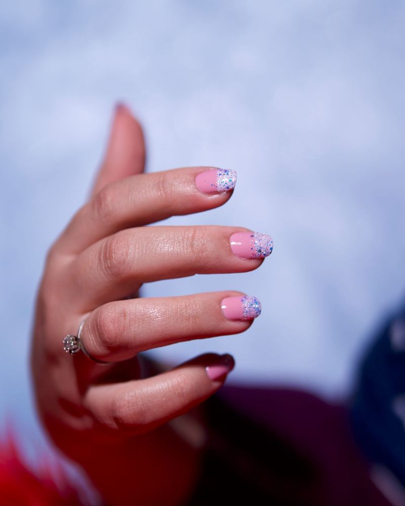 Pink glitter french against a blue sky