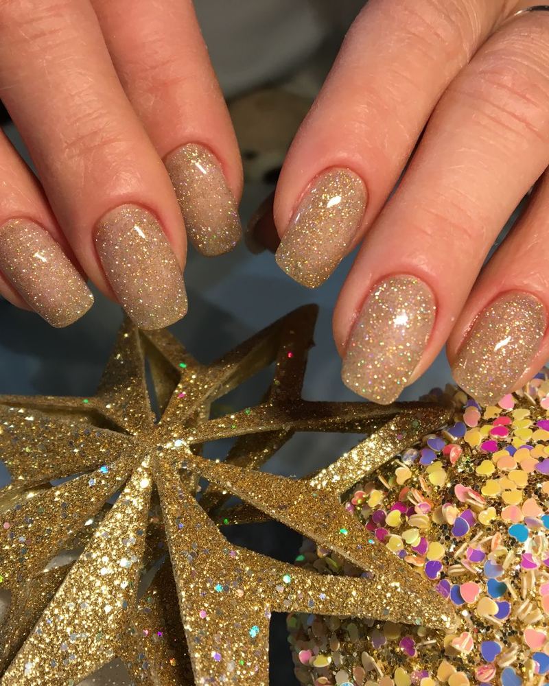 Gold glitter nails holding a sparkly star