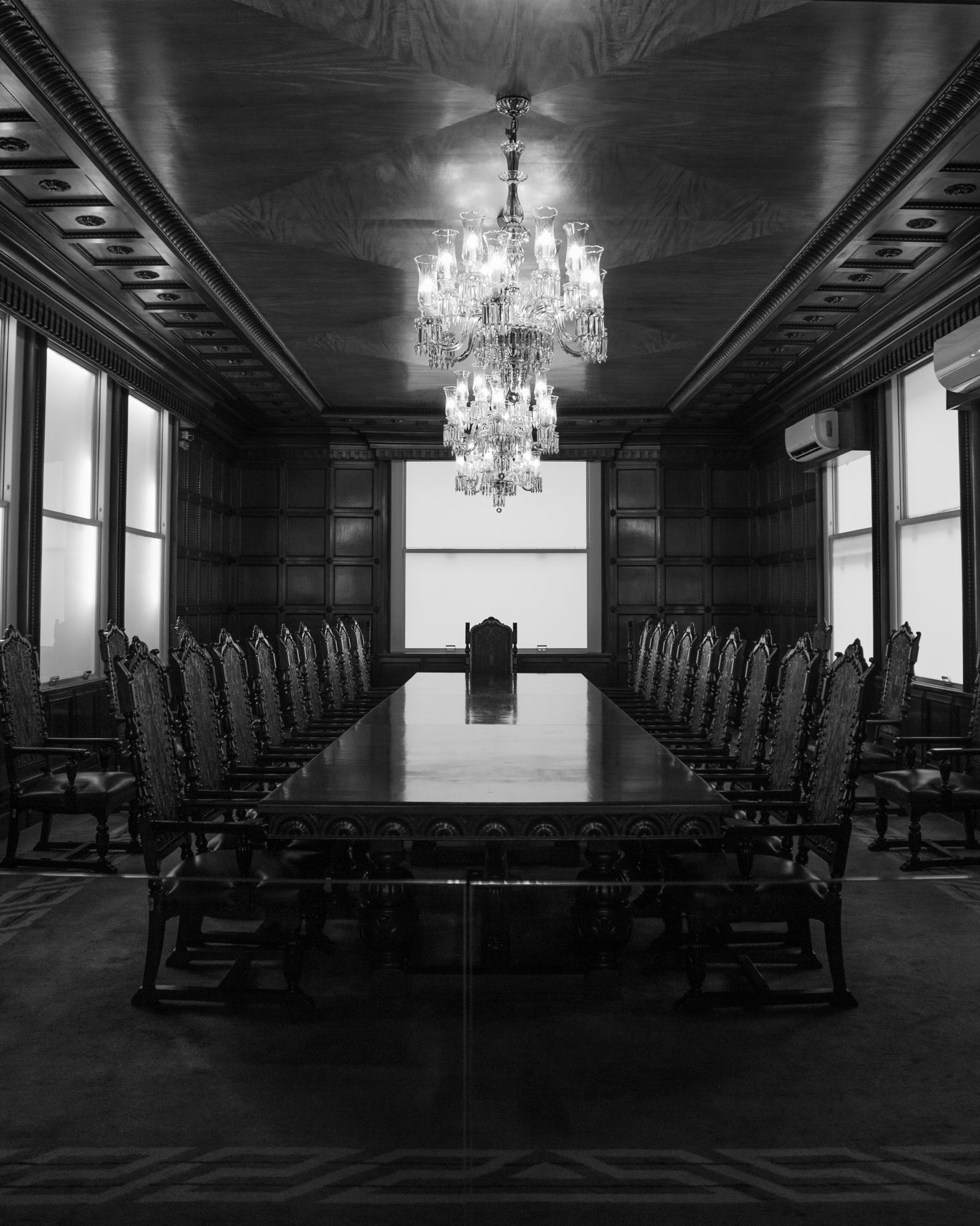 Formal boardroom with a chandelier and a long table