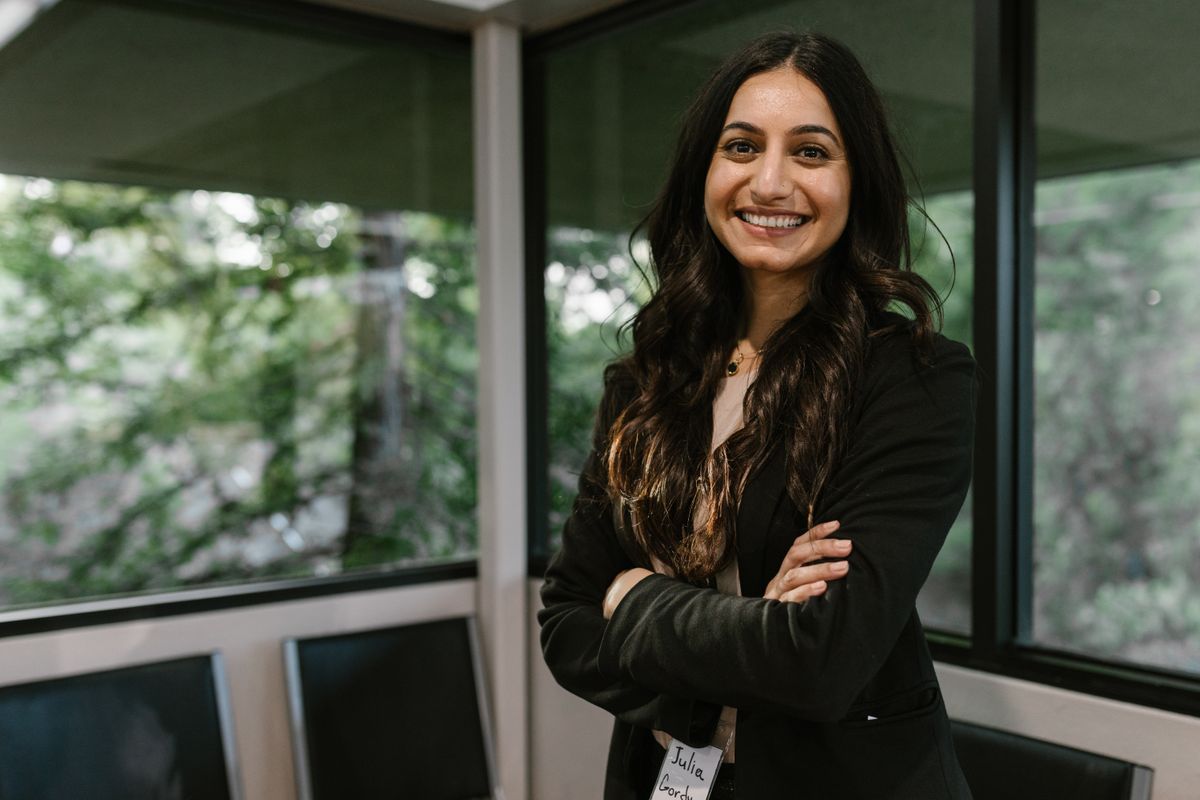 Lana Kovač smiling by the office glass wall