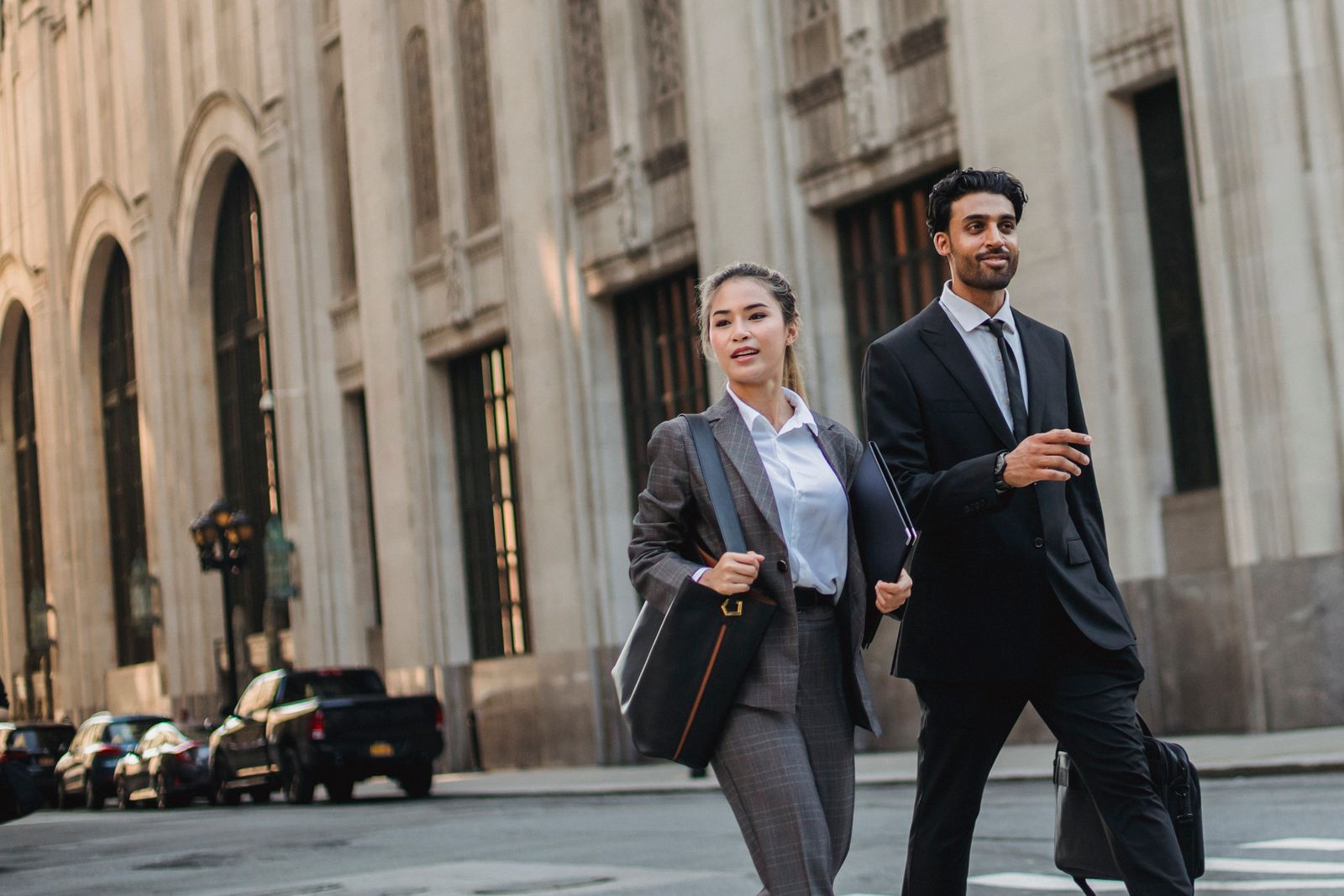 Two lawyers walking past a stone office building