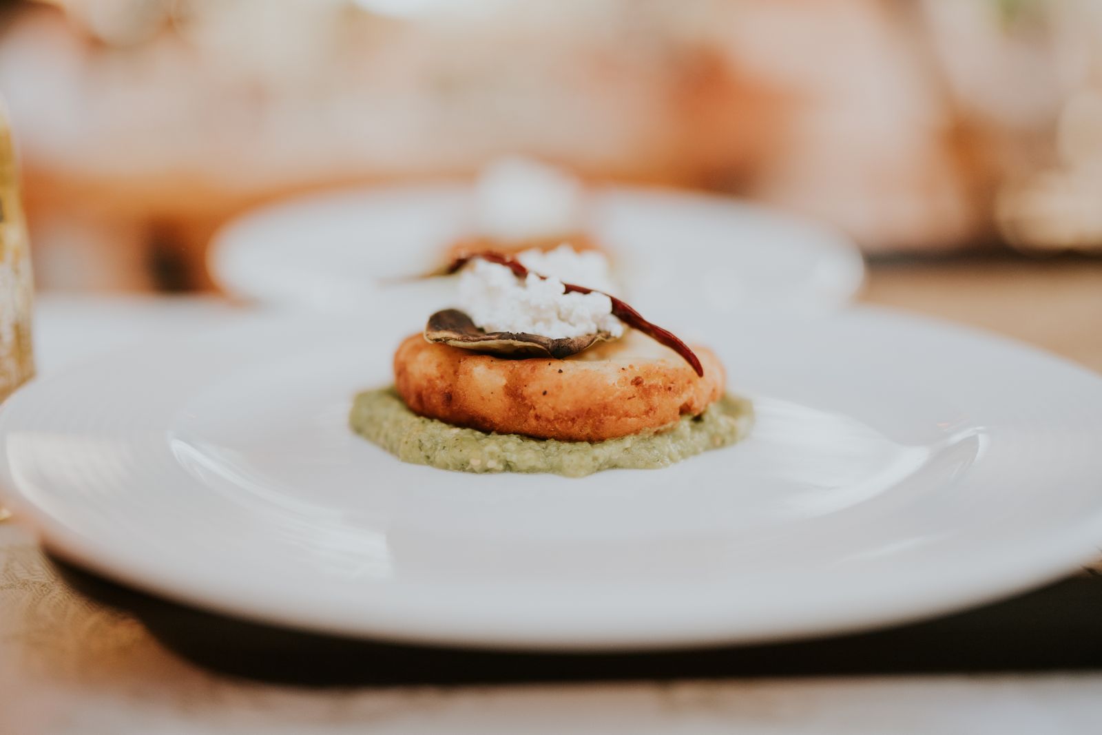 Shrimp course with herbs on a pale plate