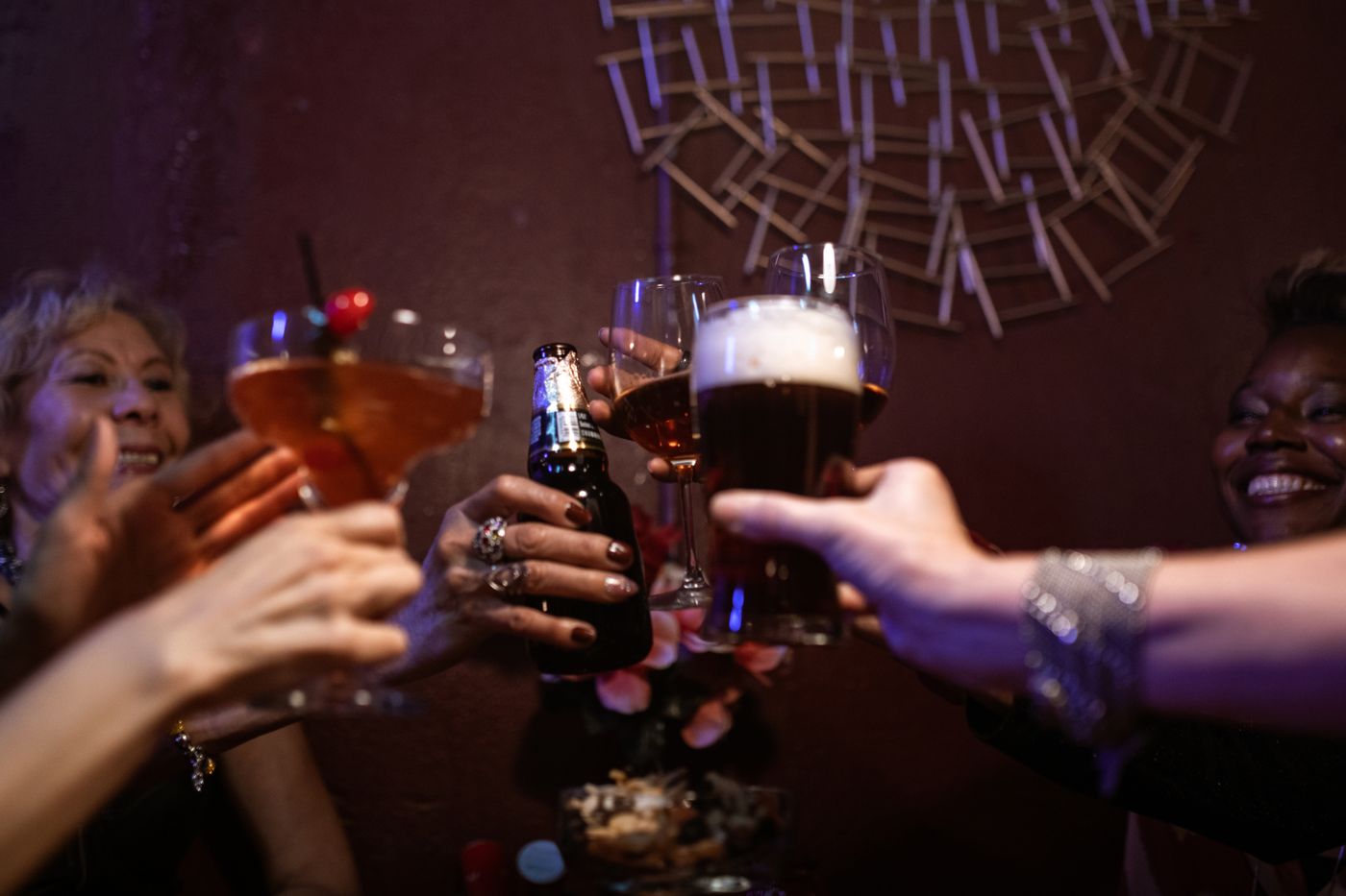 Friends toasting with drinks on quiz night