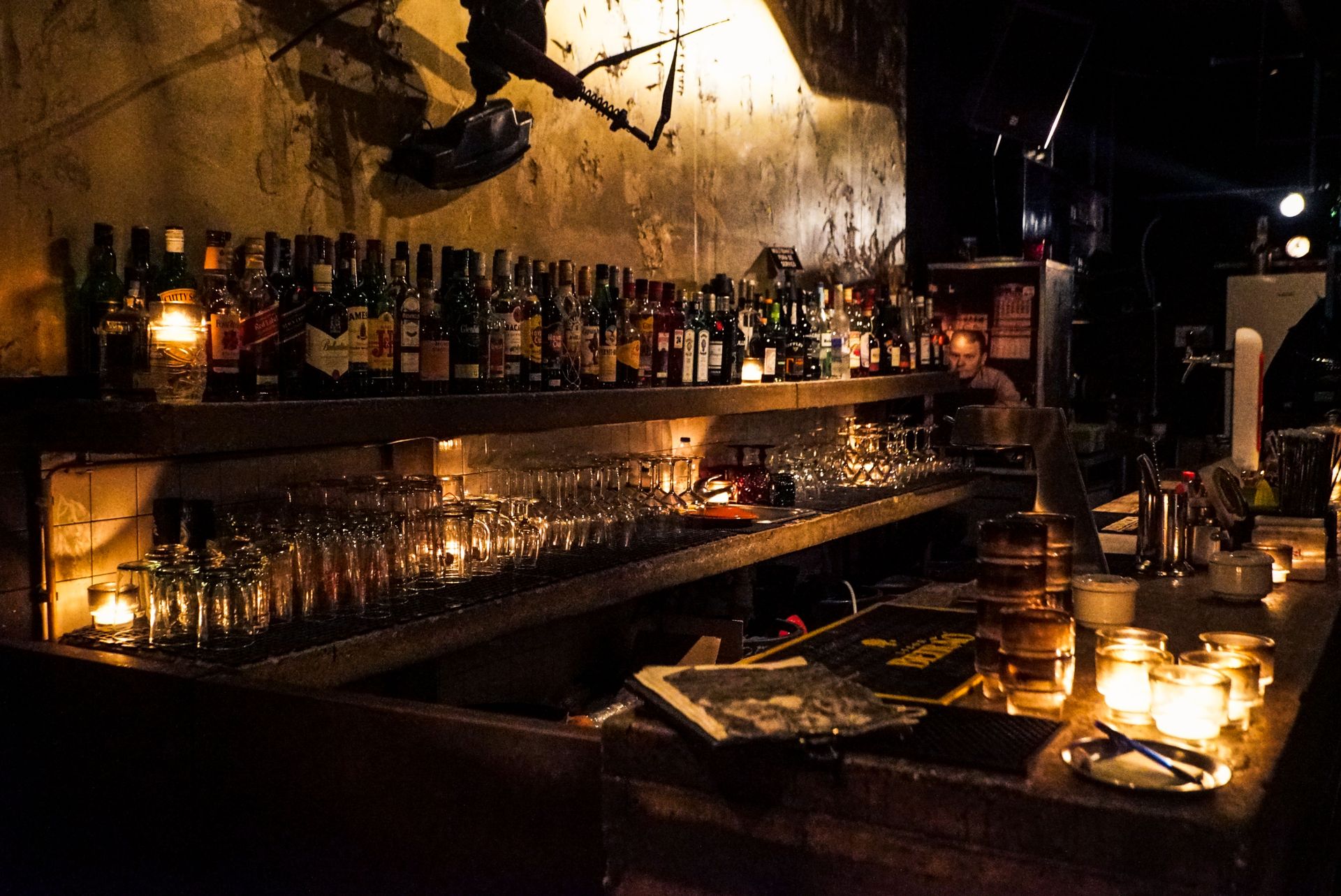 The Potter back bar at night, bottles and glasses in candlelight