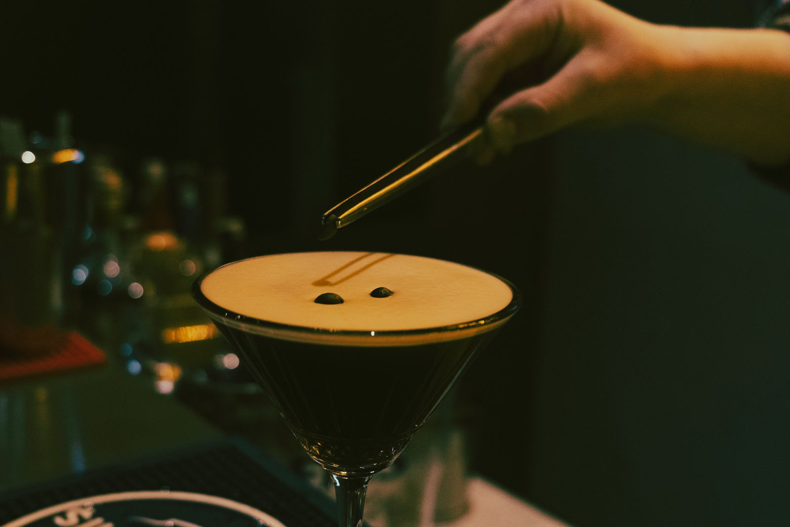 Espresso martini being garnished with coffee beans