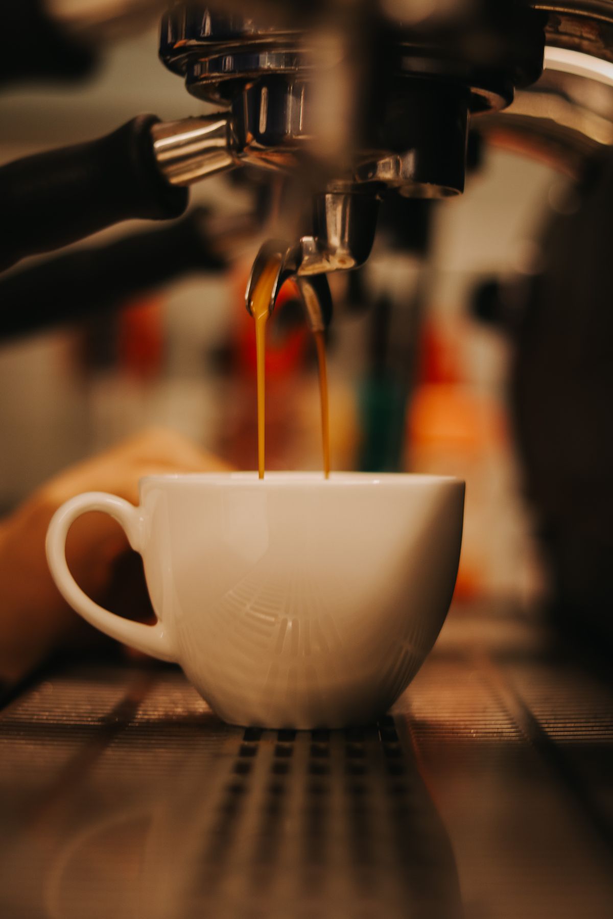 Espresso pouring into a cream cup