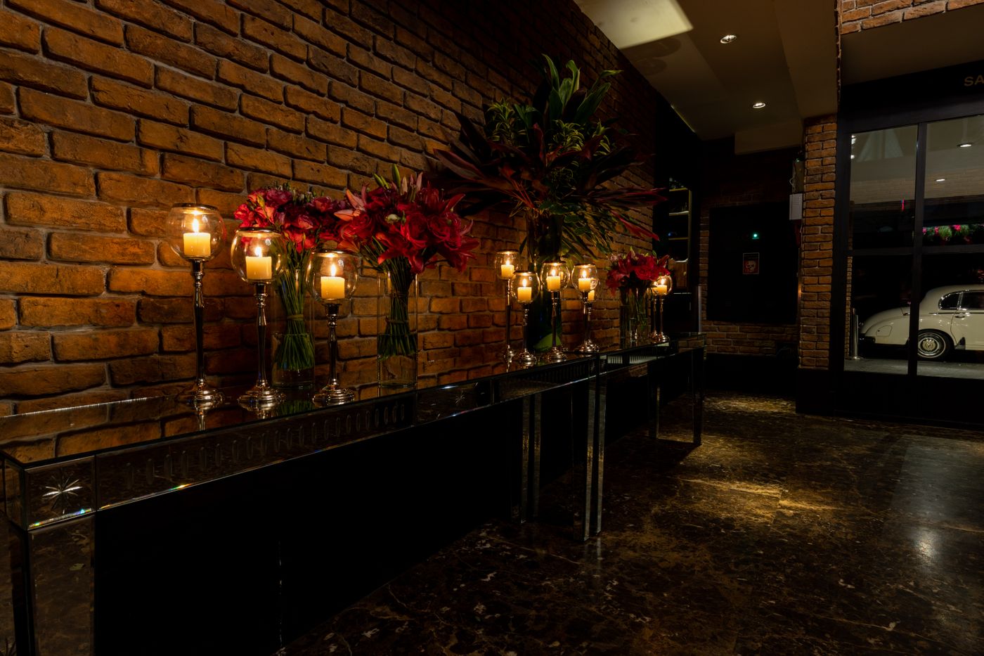 Candles burning low along the brick bar