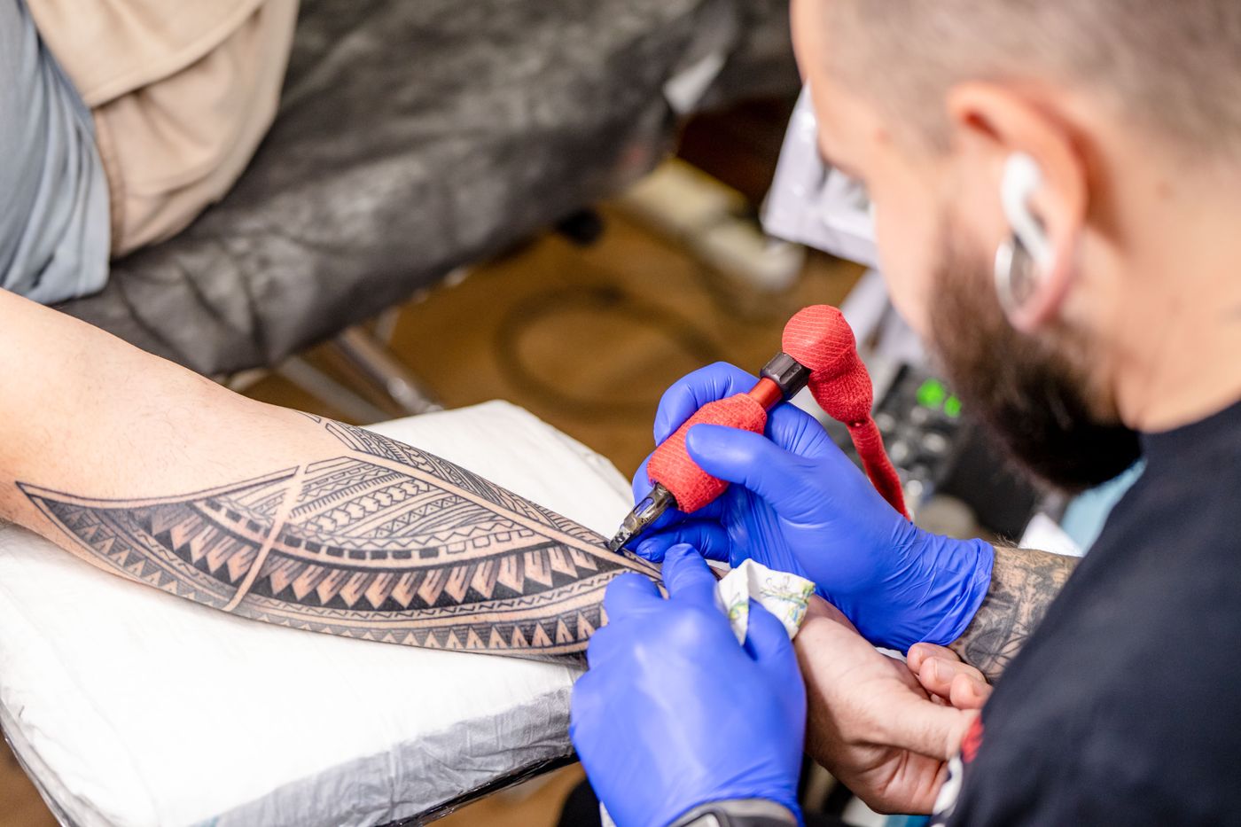 Close-up of a session in progress: gloved hands and an ornamental forearm piece