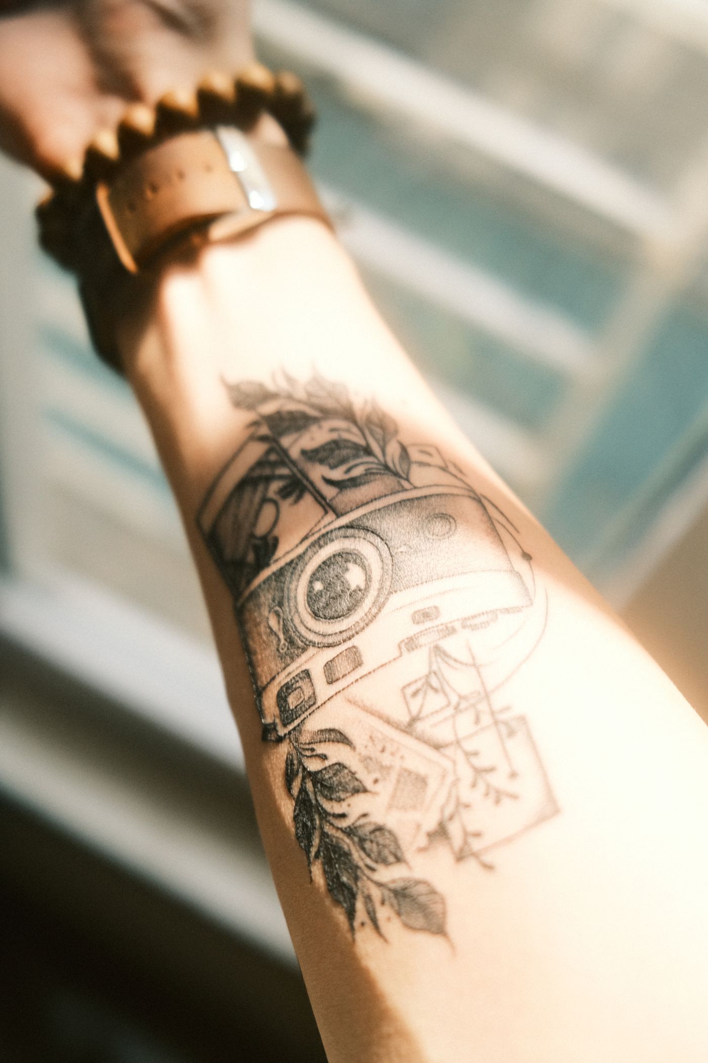 Warm-toned illustrative tattoo on a forearm