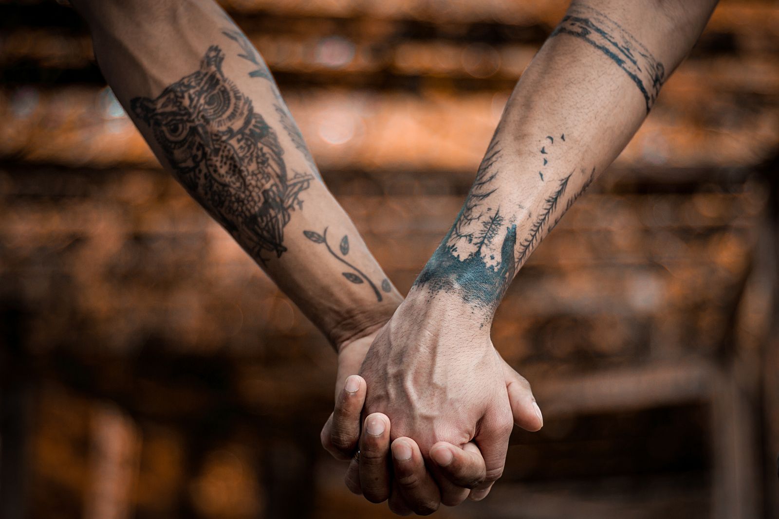 Matching linework tattoos on two held hands